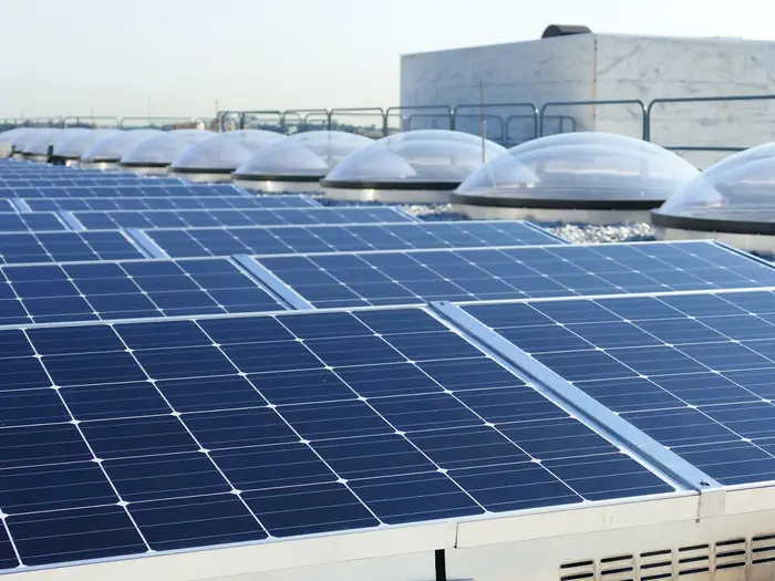Rows of solar panels mounted on a commercial office building rooftop