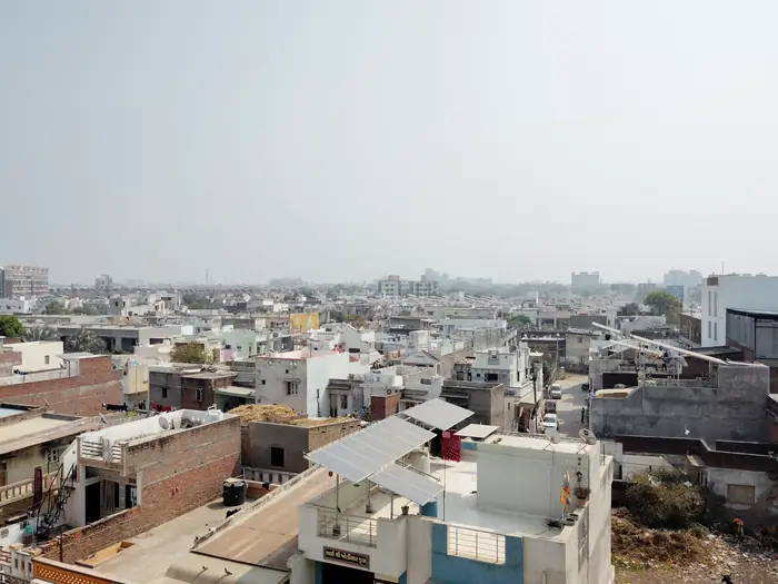 Rooftop solar panels installed on a home amid a dense Indian residential neighbourhood